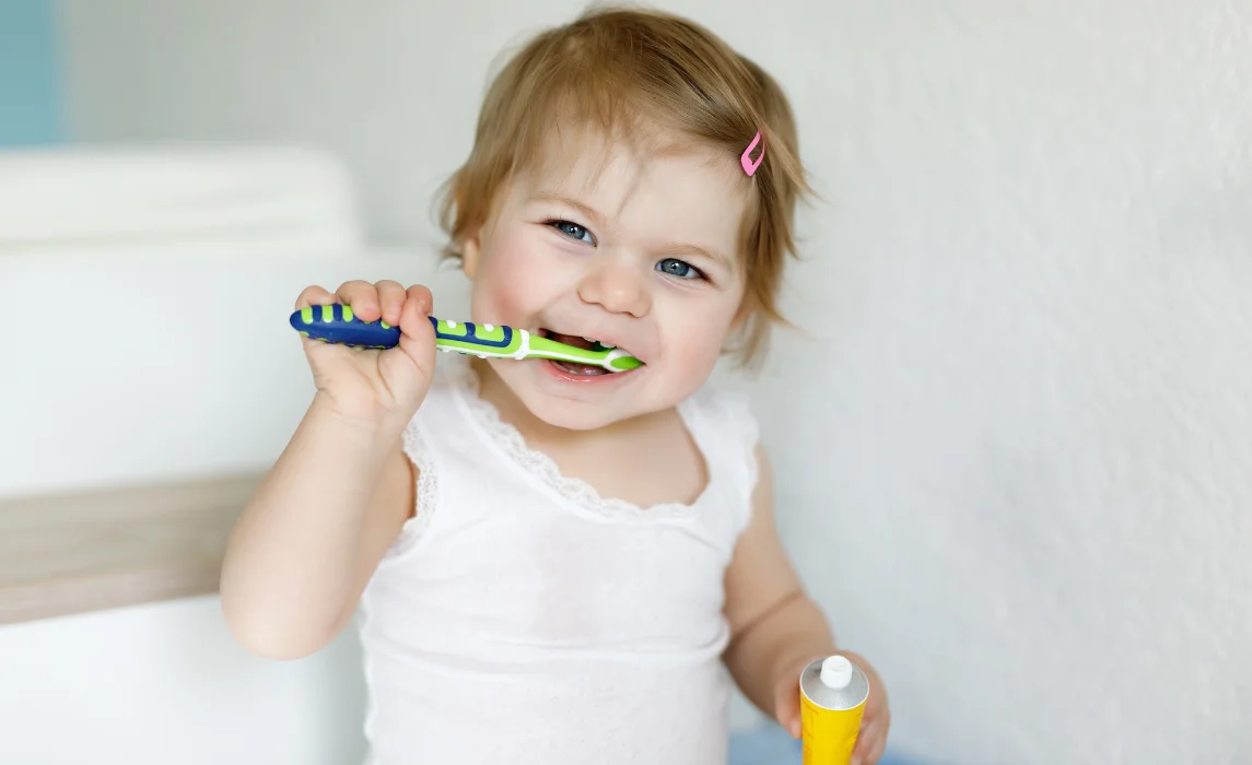 baby holding the toothbrush