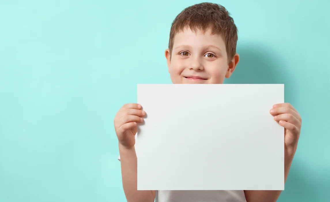 kid holding a paper in teal background