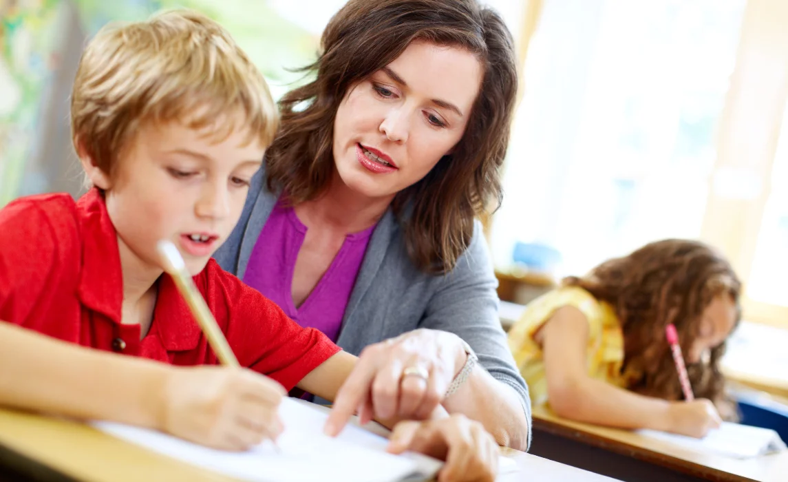 teacher teaching a kid to write
