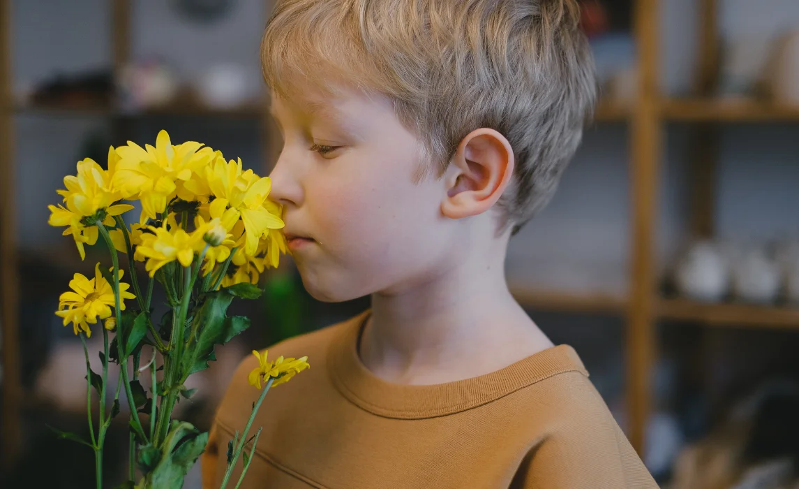 kid smelling the yellow flowers