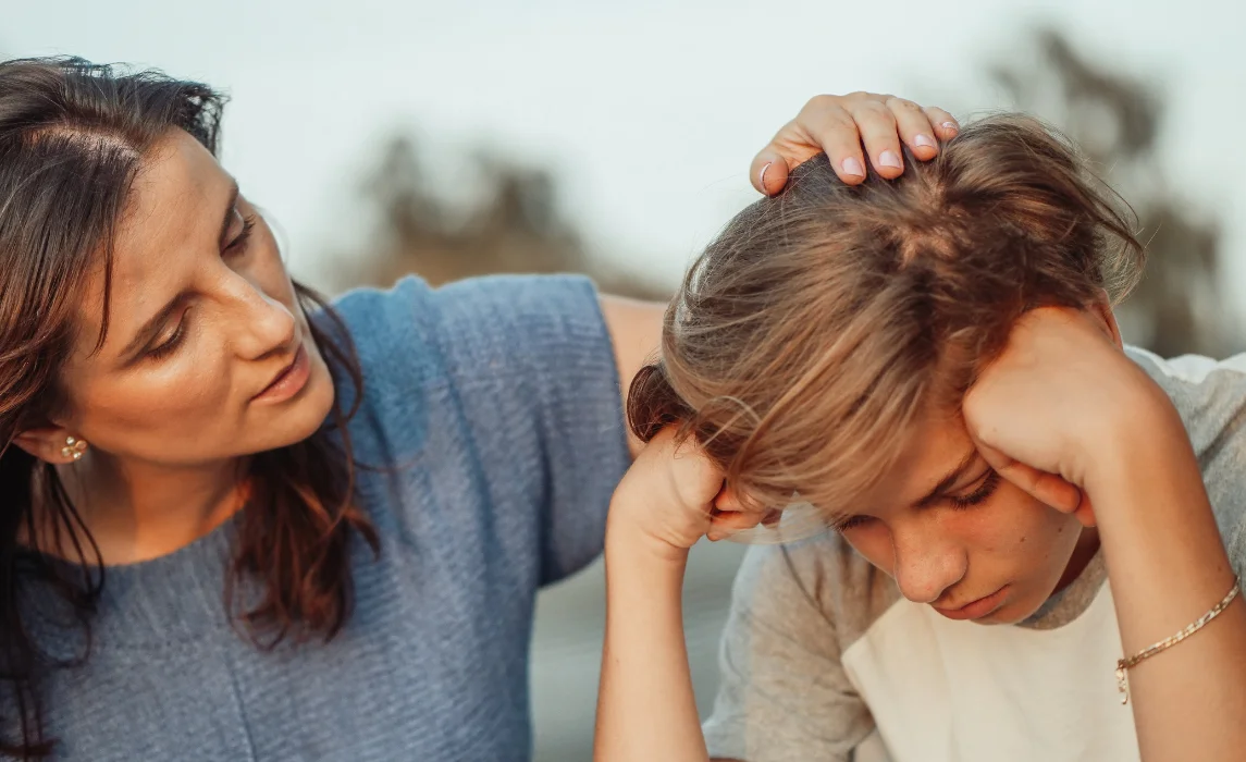 kid being consoled by an adult