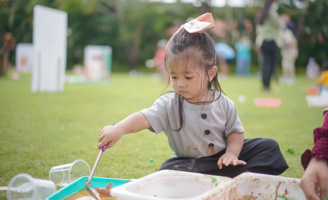 kid playing with mud in the park