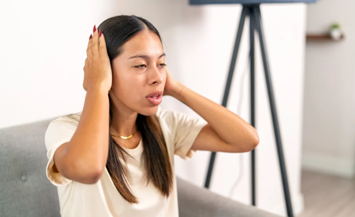 girl covering her ears in her apartment