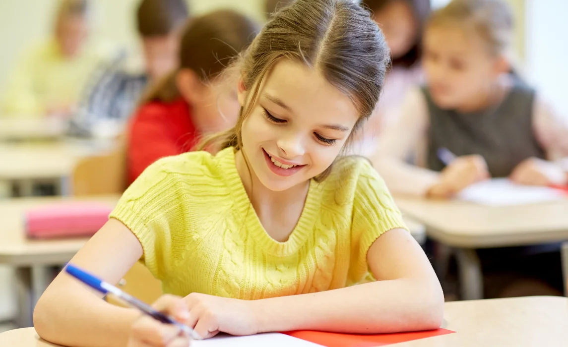 kid writing in her desk