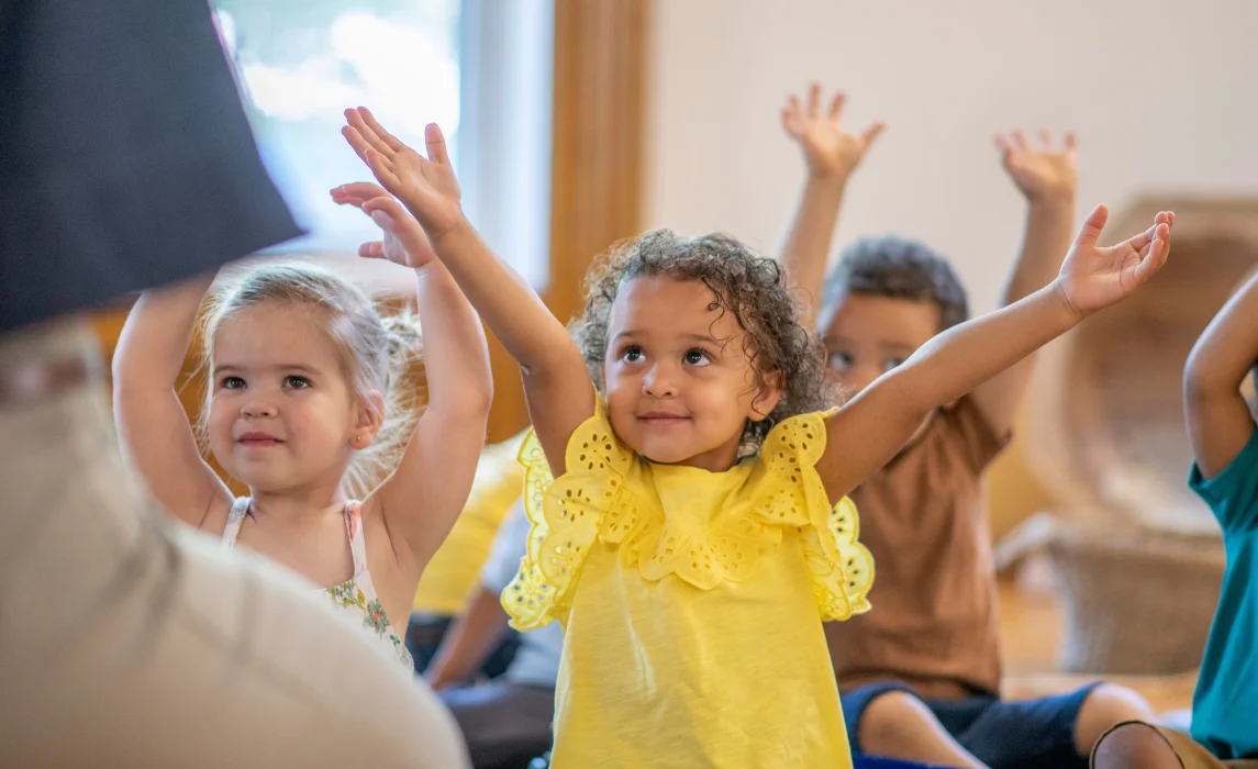 kid raising their hands up