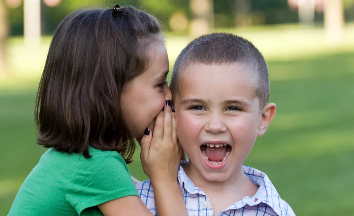 kid whispering to another kid
