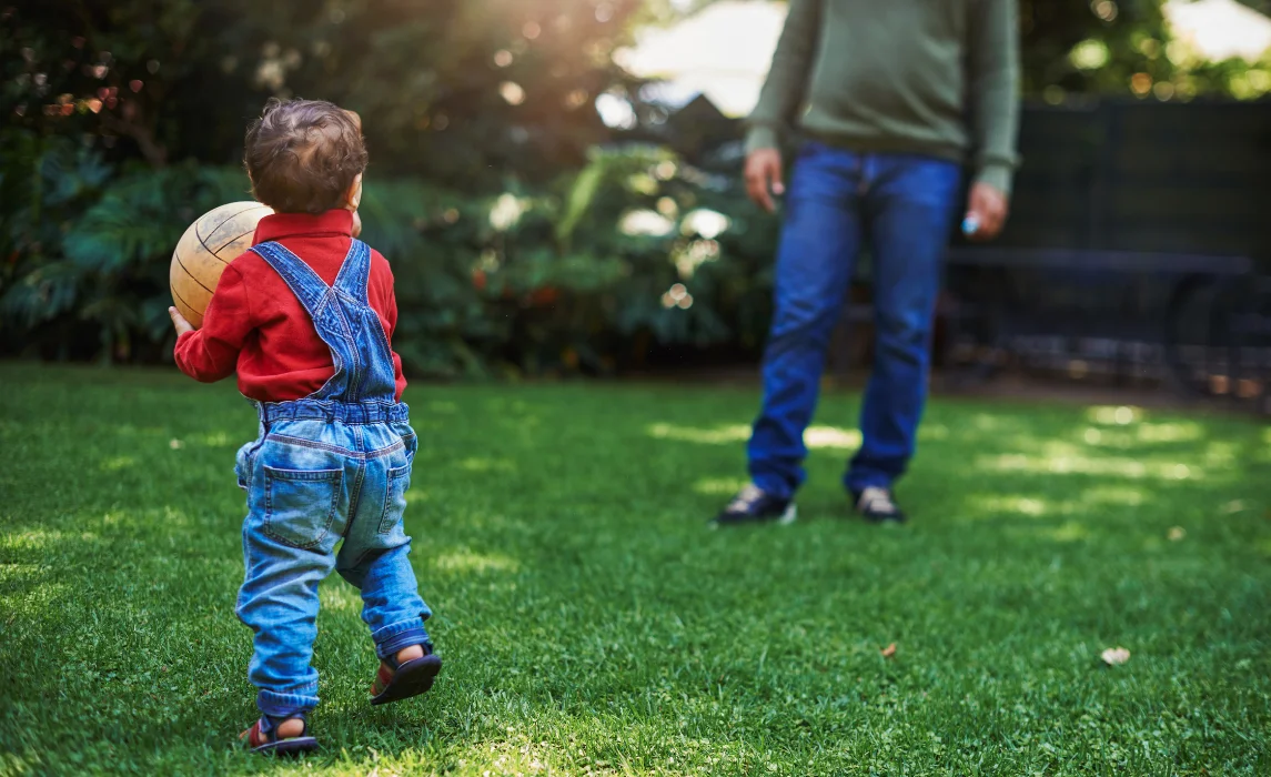 kid playing ball with his dad