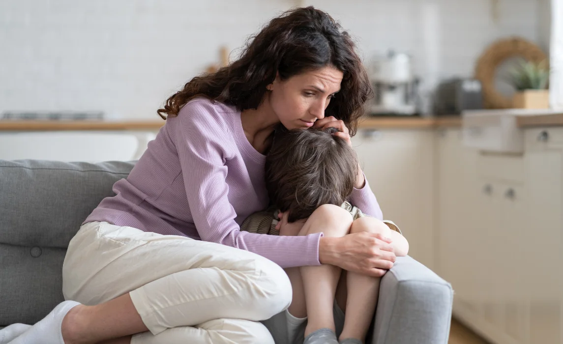 kid being comforted by her mother