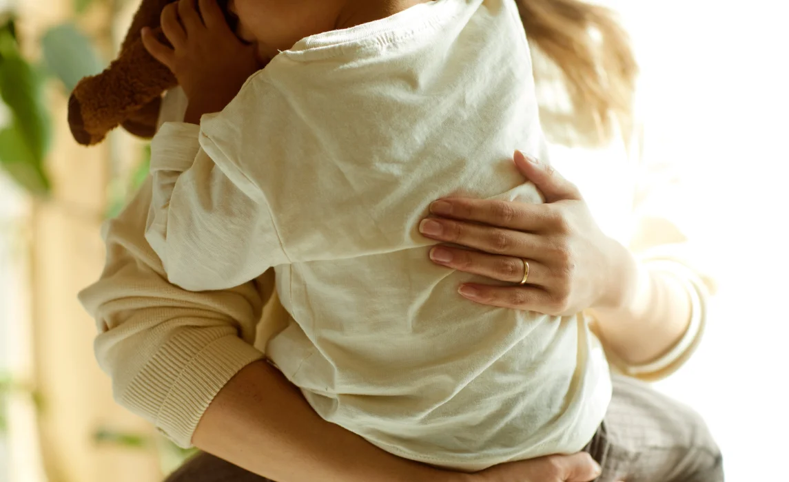 kid carried by her mom