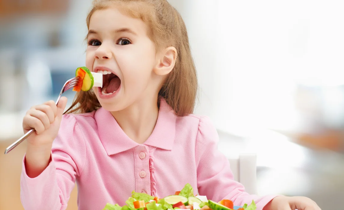 kid eating vegetable in fork