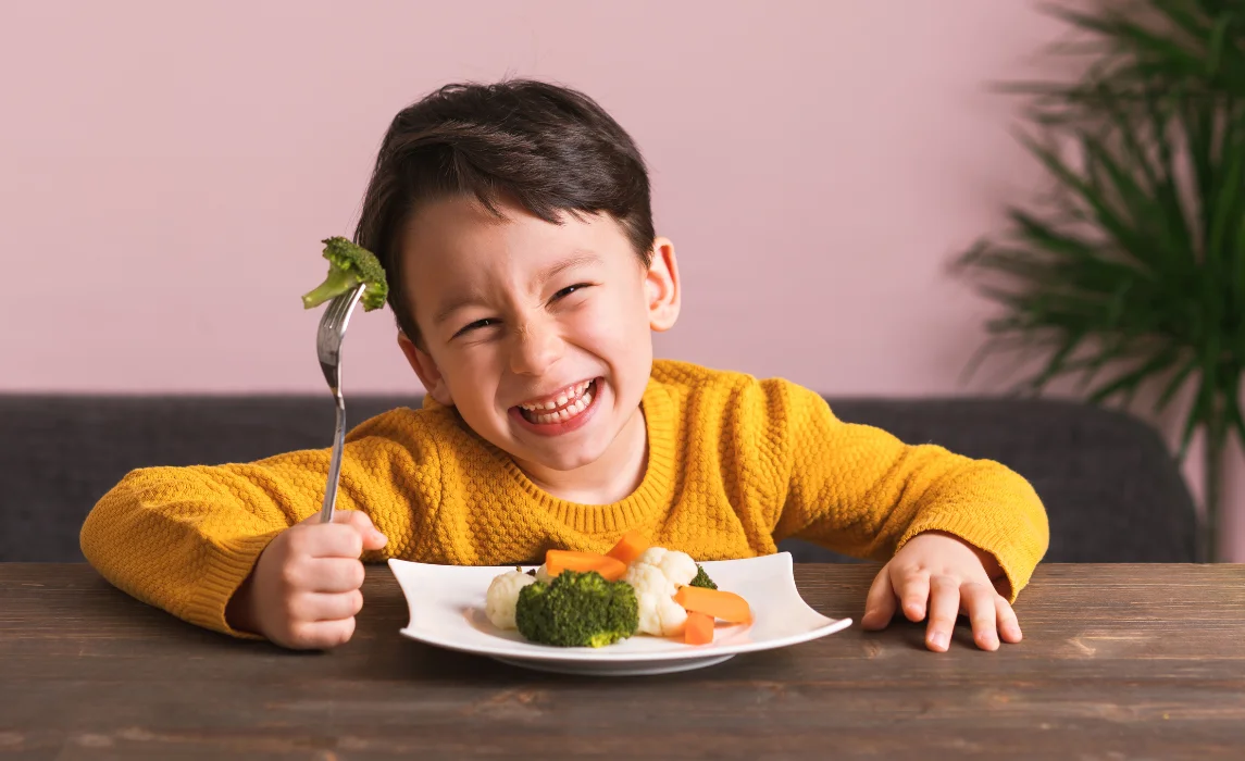 kid happily eating broccoli