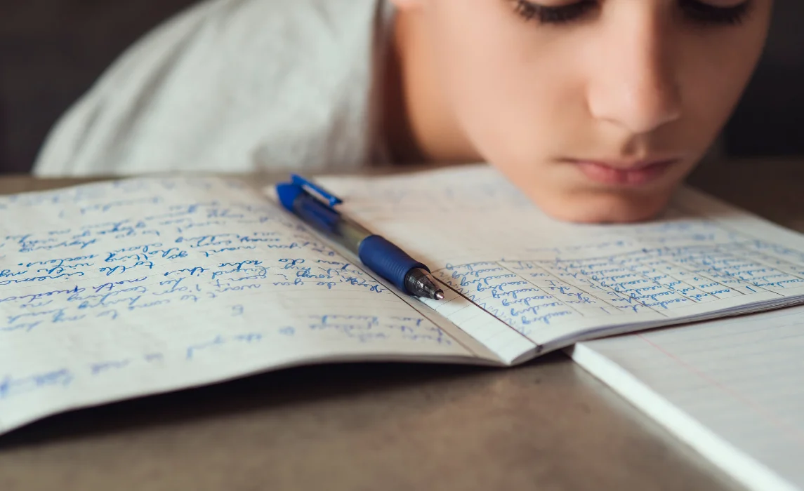 kid writing in his notebook