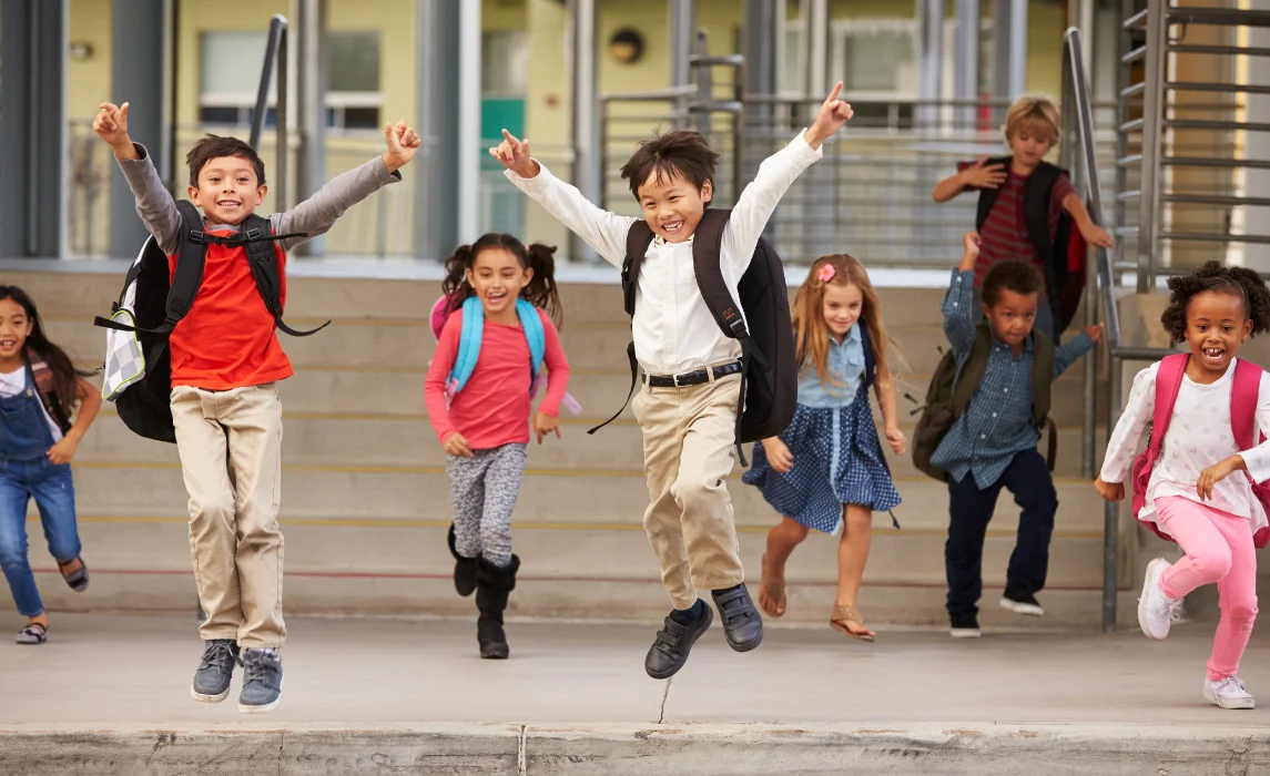 kids jumping out of joy outside the school
