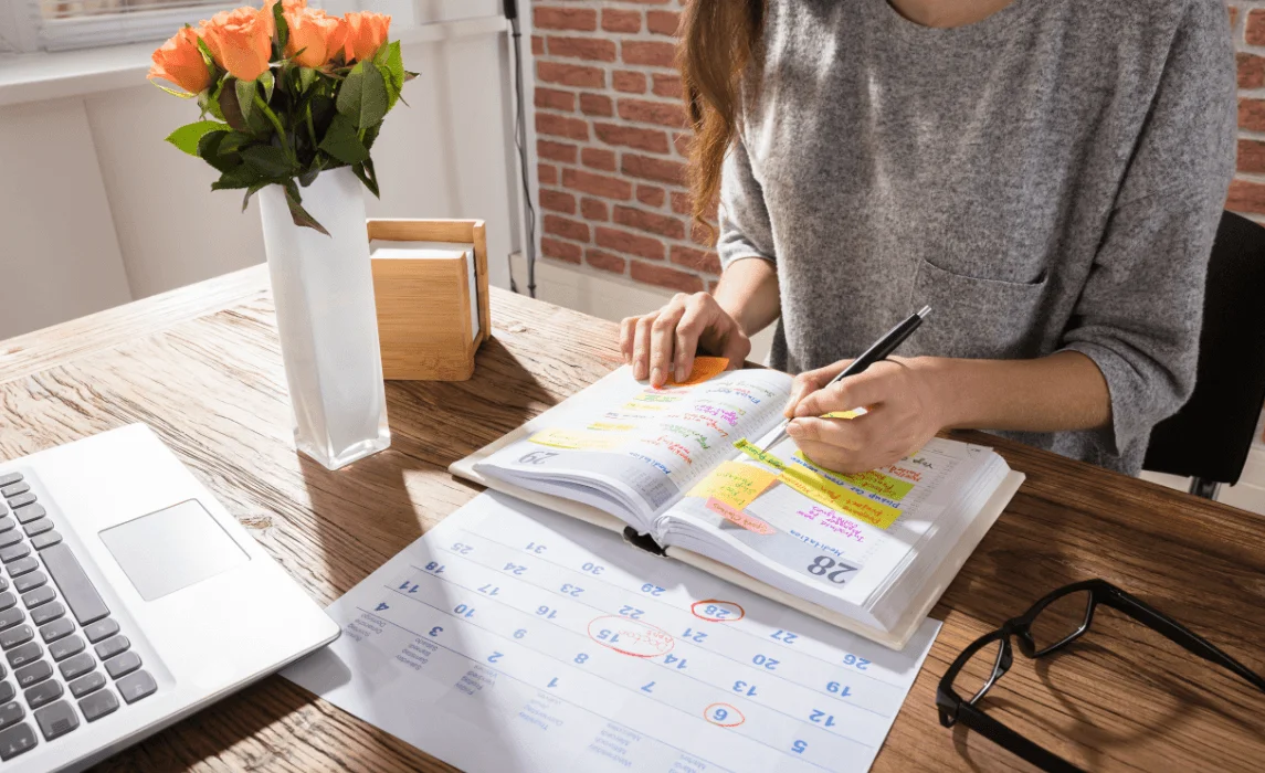 person taking notes on a calendar