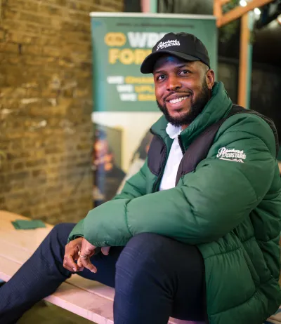 Man wearing green jacket and smiling