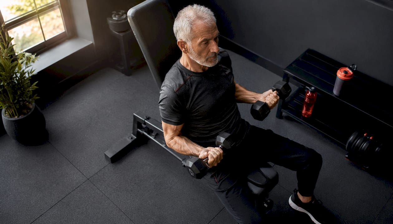 Senior man doing resistance training in gym