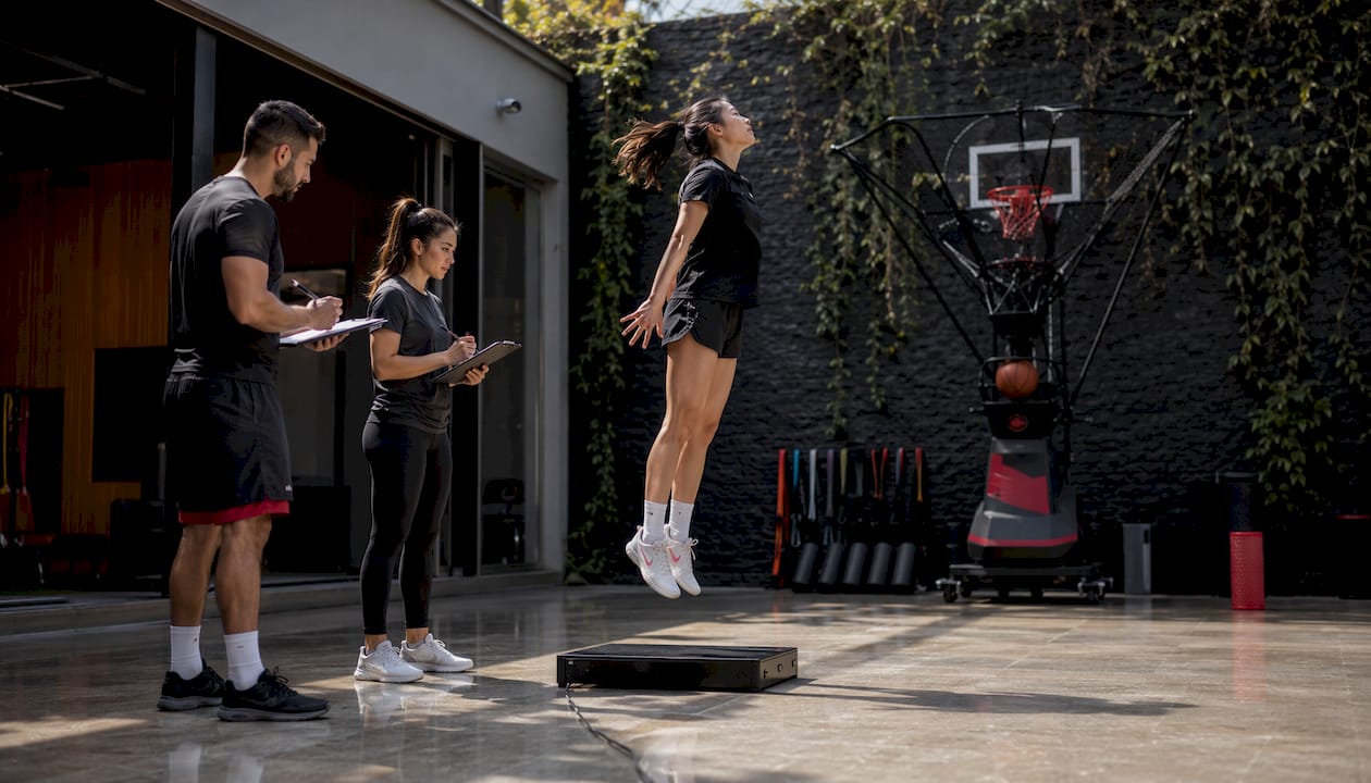 Athlete performing jump test in PT-integrated training studio