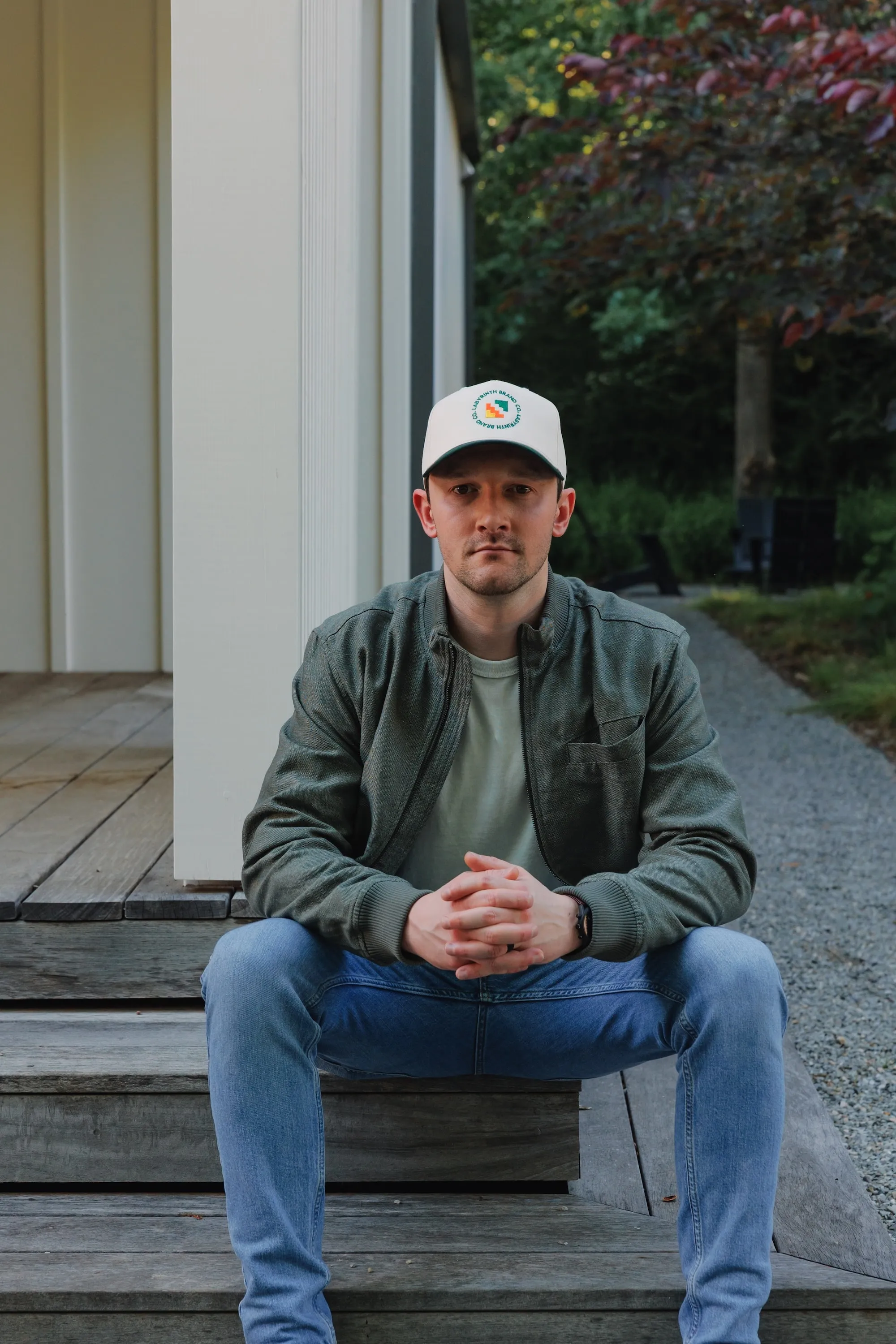 Keeton Storts seated outside wearing a green jacket and Labyrinth Brand Co hat