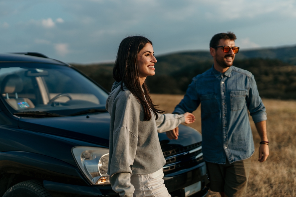 Couple walking together in front of their leased car