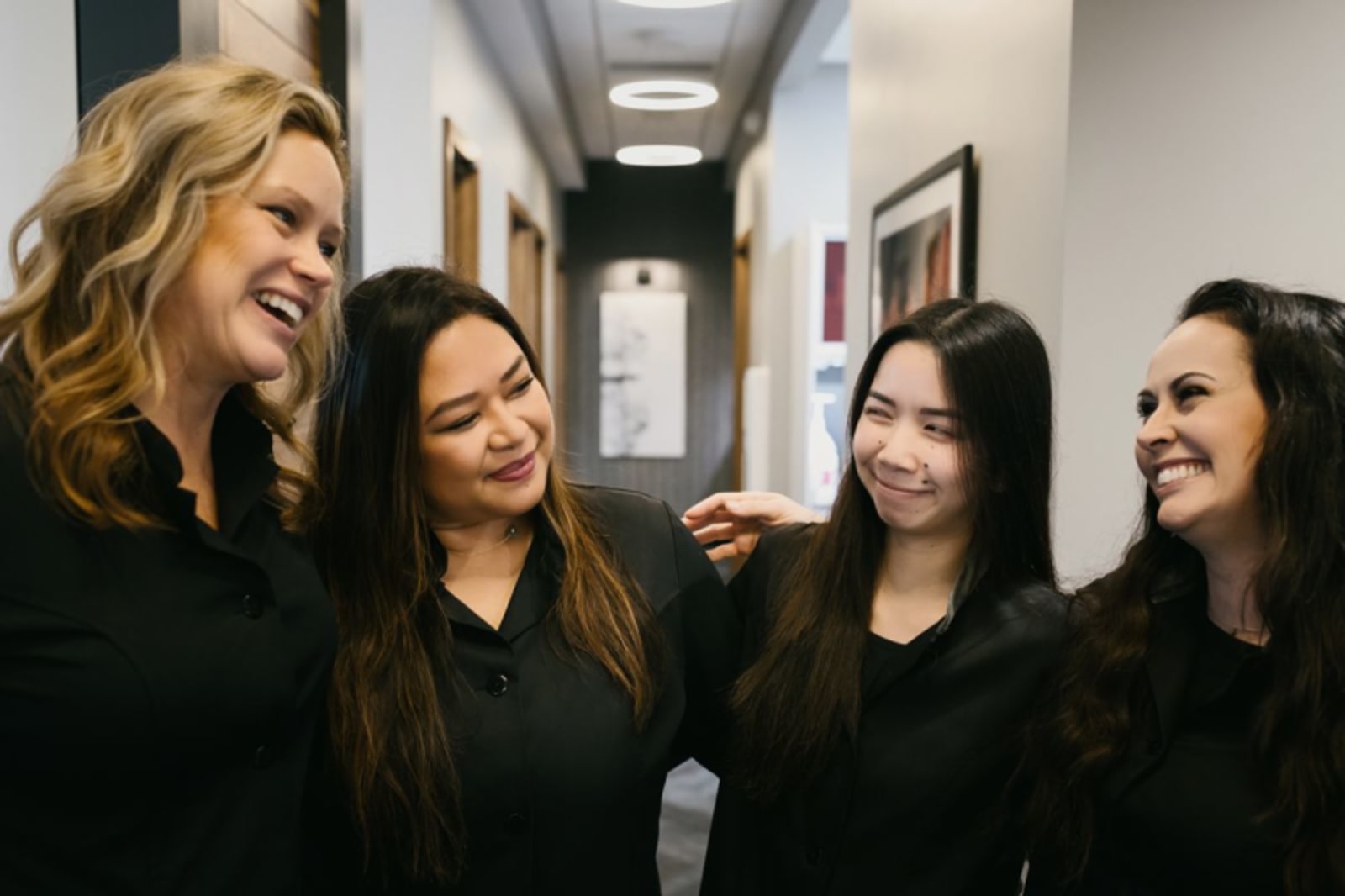 Cedarbrook Dental team members smiling together in office hallway