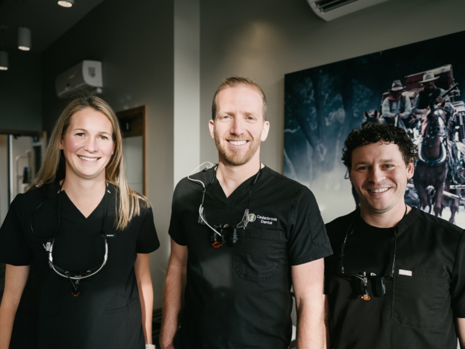 Cedarbrook Dental team smiling in clinical setting