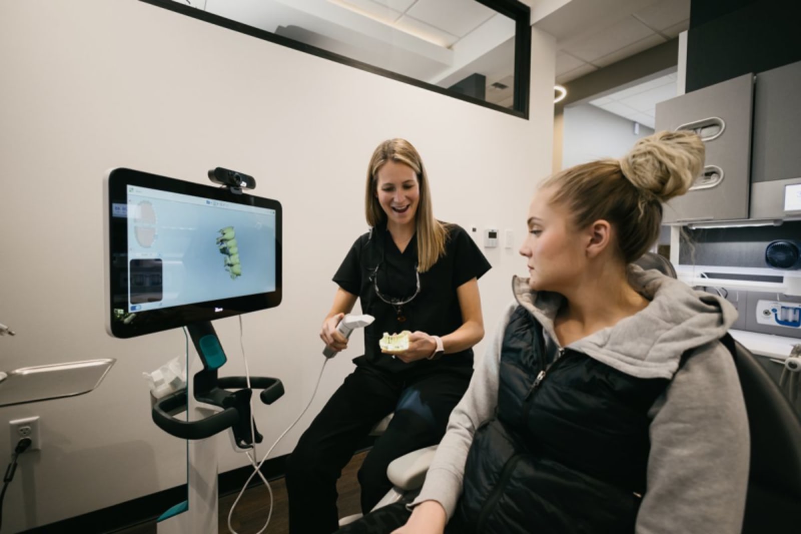 Dental professional discussing treatment options with patient using digital display