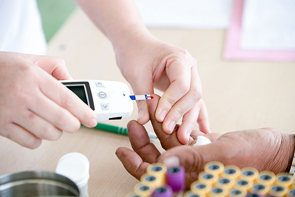 enfermero revisando glucosa en la sangre de un paciente