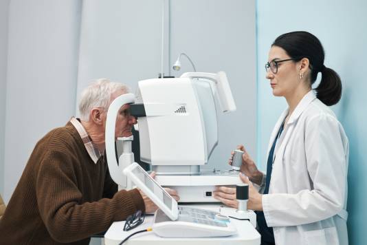 especialista en salud visual revisando a un adulto mayor