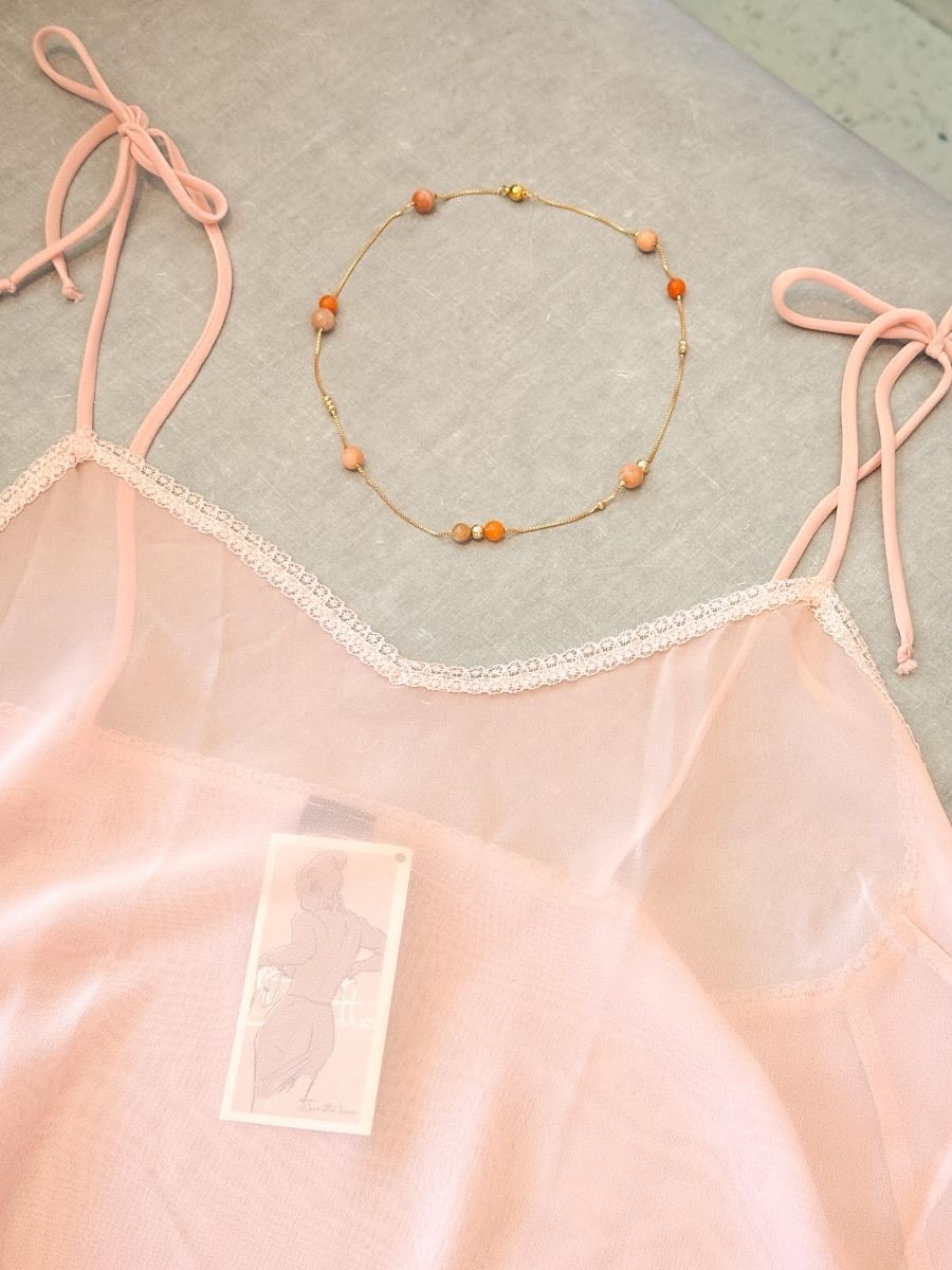 A pink camisole with a necklace