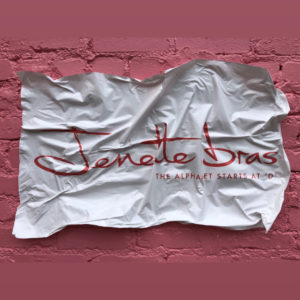 A crumpled Jenette Bras business card