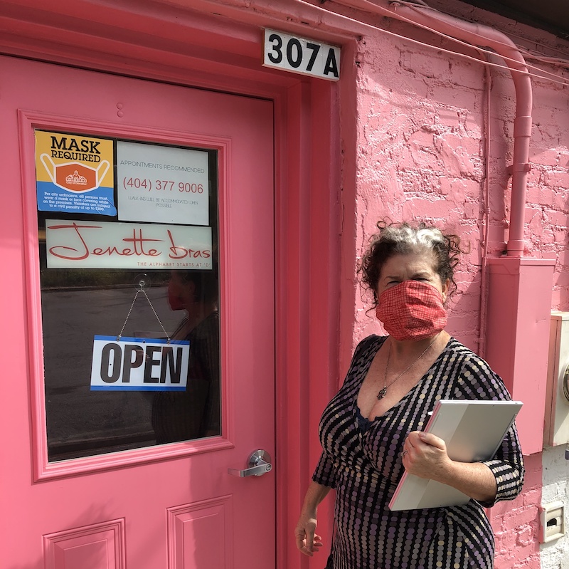 Jenette with a mask in front of the Jenette Bras Decatur location