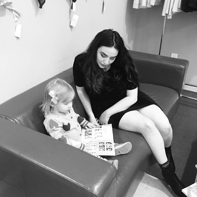 A black and white photo of a woman reading to a toddler