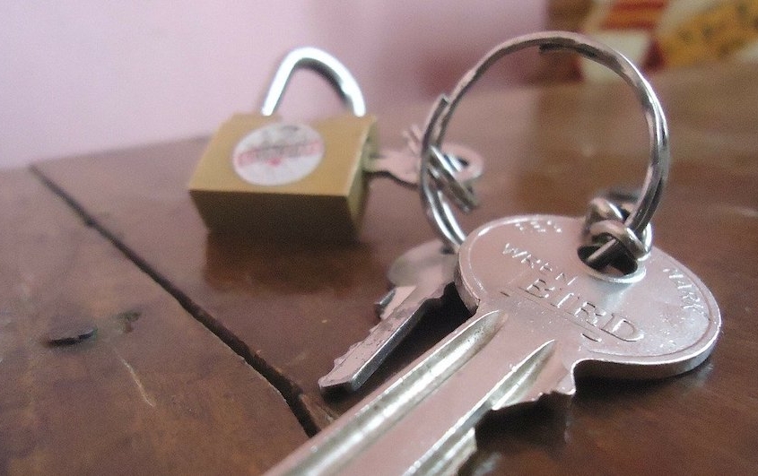 Schlüssel und Schloss auf Tischplatte