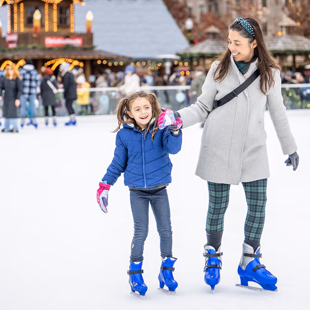 A woman and a little girl on ice skates.