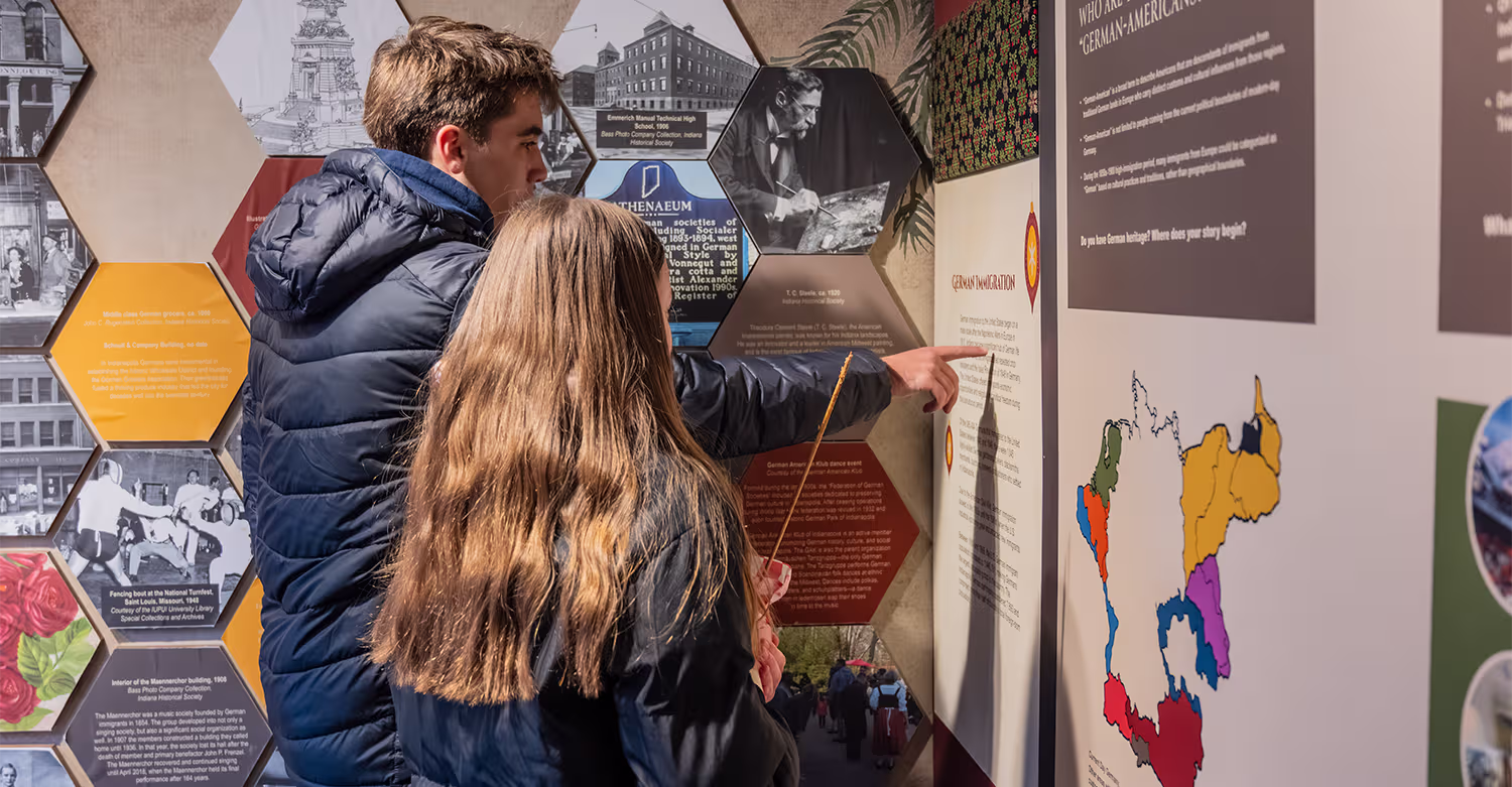 Two visitors read a “Germans in Indiana” exhibit about German-American heritage.