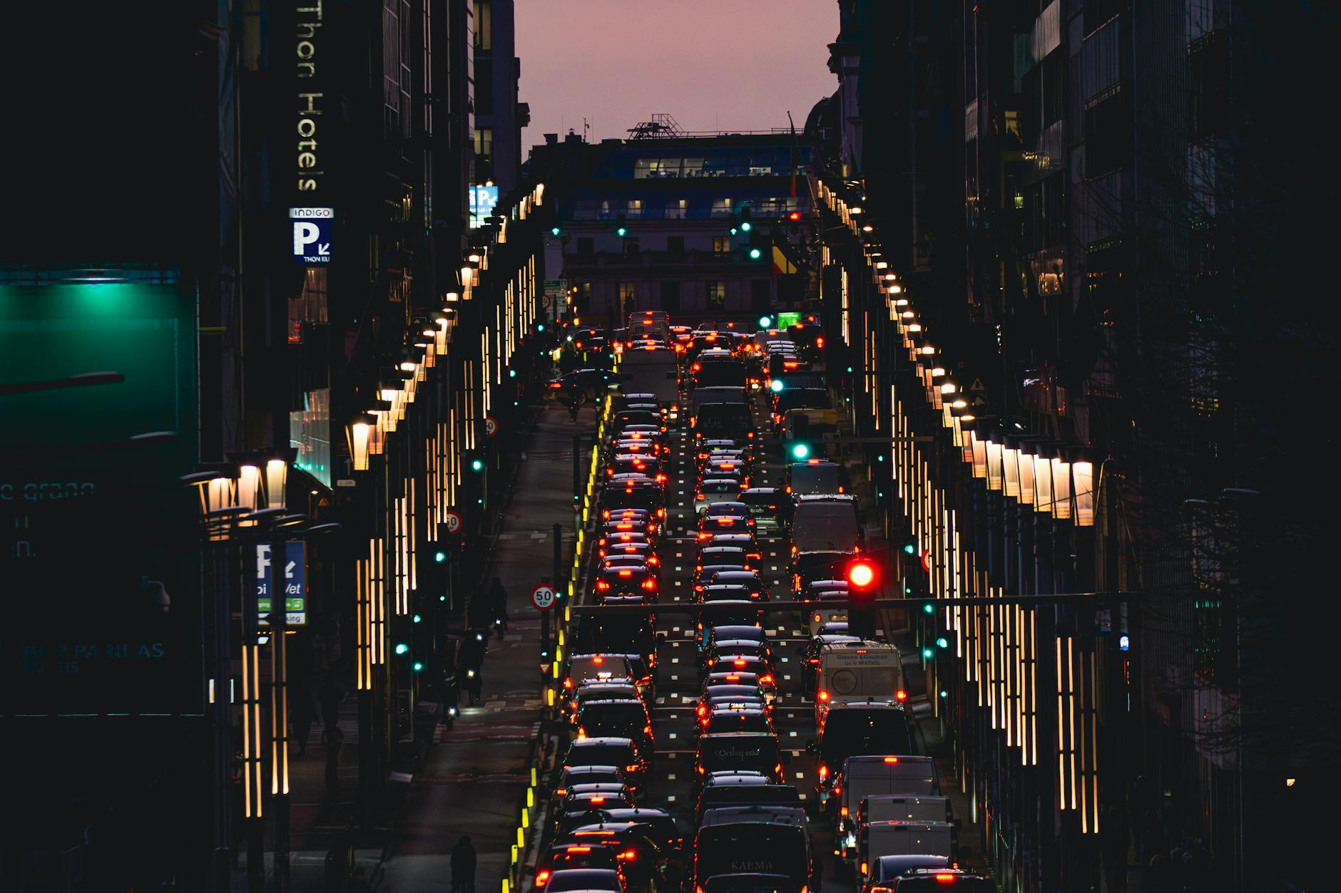 Nighttime cityscape showing dense traffic on a lit street in Brussels, Belgium.