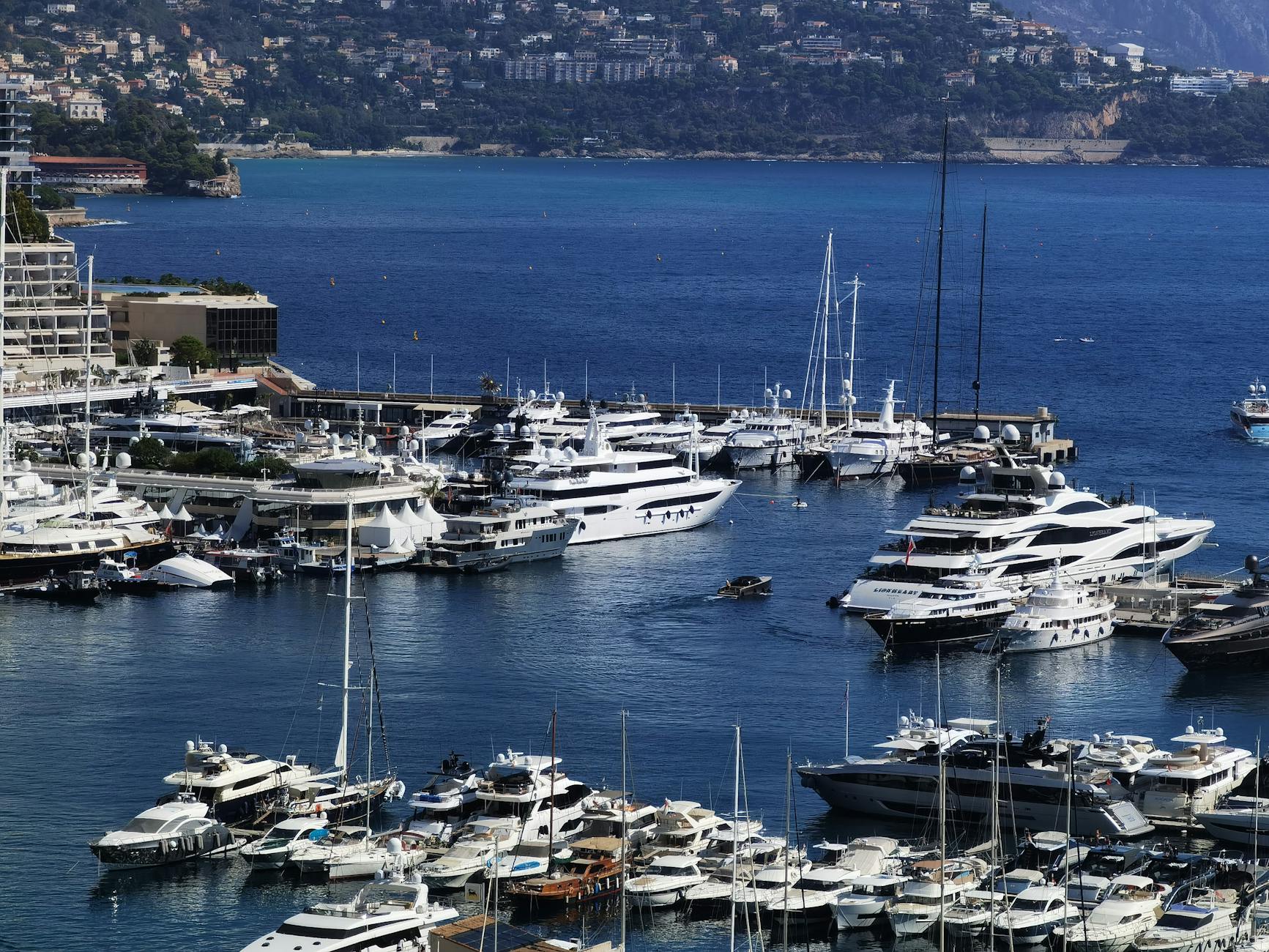 Discover the opulence of Monaco's marina, showcasing luxury yachts against a stunning Mediterranean backdrop.