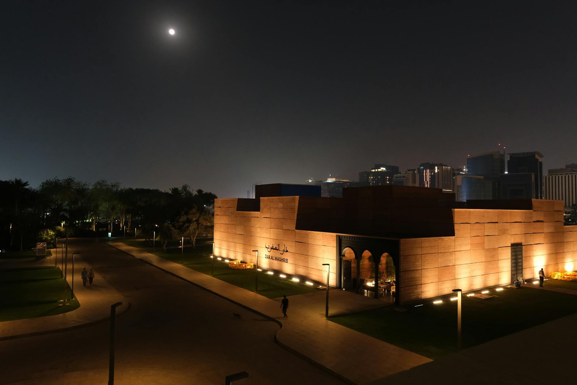 Stunning night view of Doha's Fire Station building illuminated under moonlight with a city backdrop.