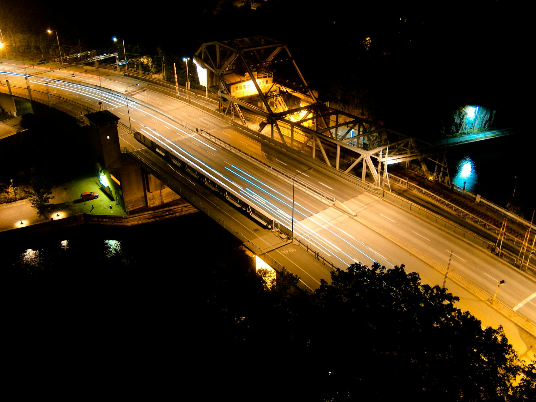 Aerial long exposure of a bridge in Norrmalm, Sweden, showcasing light trails and urban nightlights.
