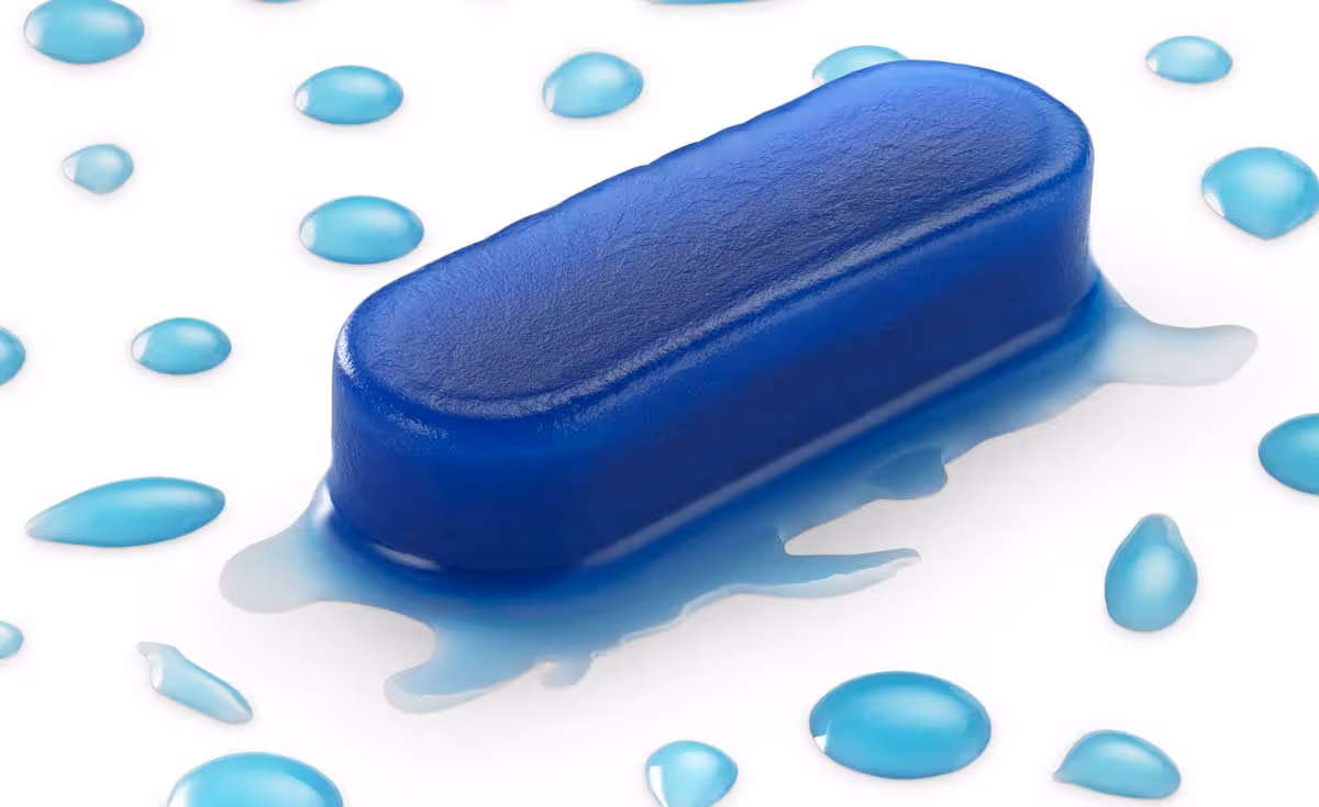 Close-up of a hemostatic dressing on a white surface with water droplets scattered around.