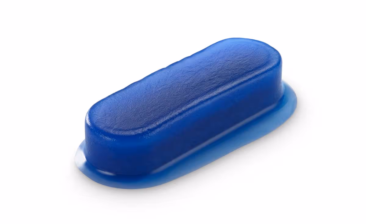 Close-up of a hemostatic dressing on a white surface with water droplets scattered around.