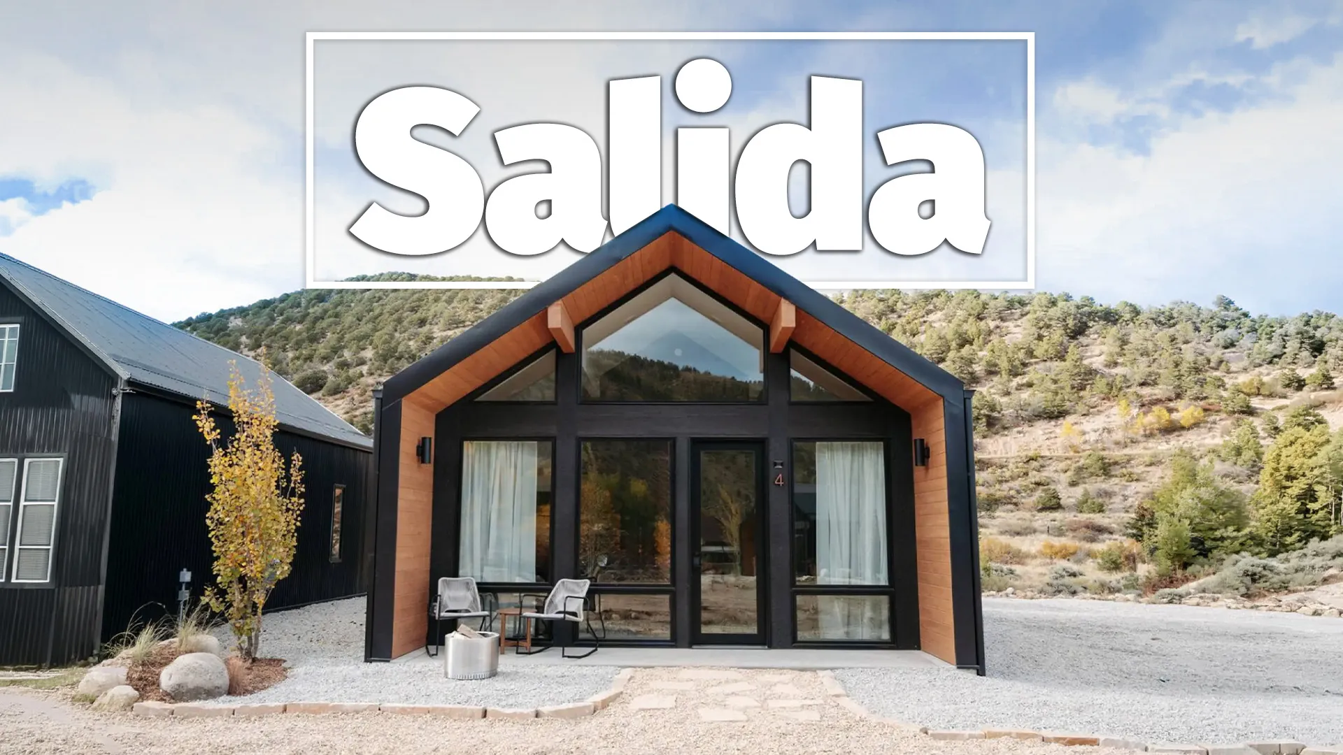 Modern cabin with Salida signage nestled in foothills with desert vegetation and mountains.