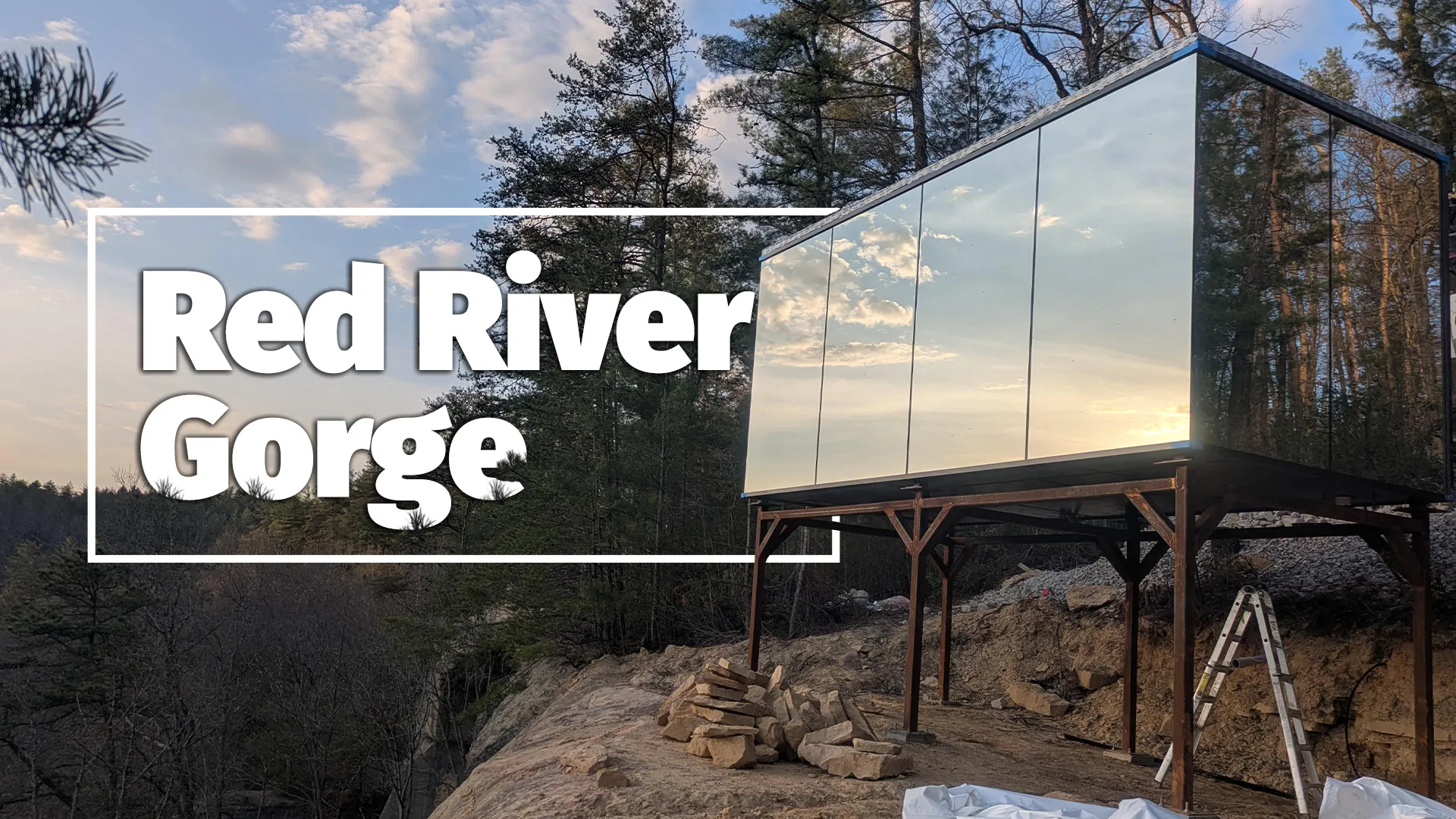 Modern glass structure at Red River Gorge with forest and blue sky backdrop