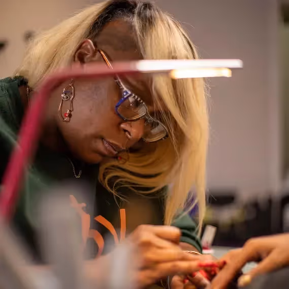 Nail artist working in a salon with a popular name