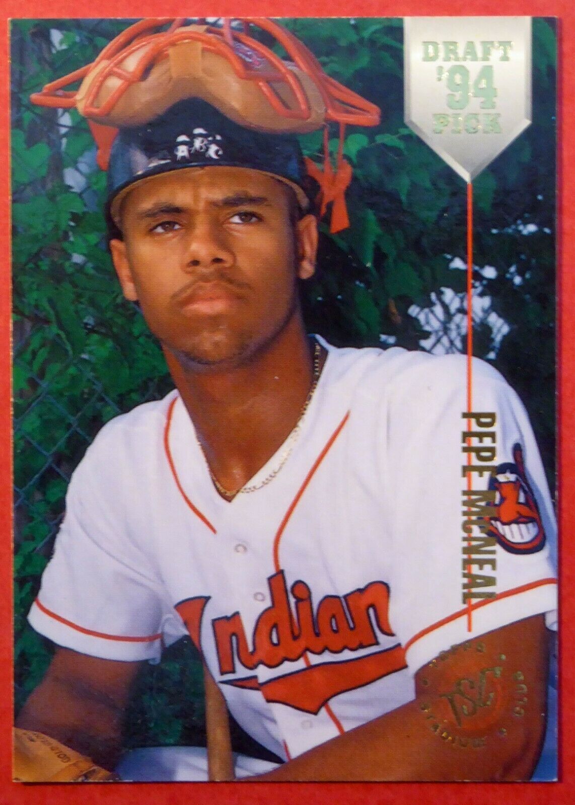 Pepe McNeal in Indian baseball jersey with catcher's mask on head and glove in hand.