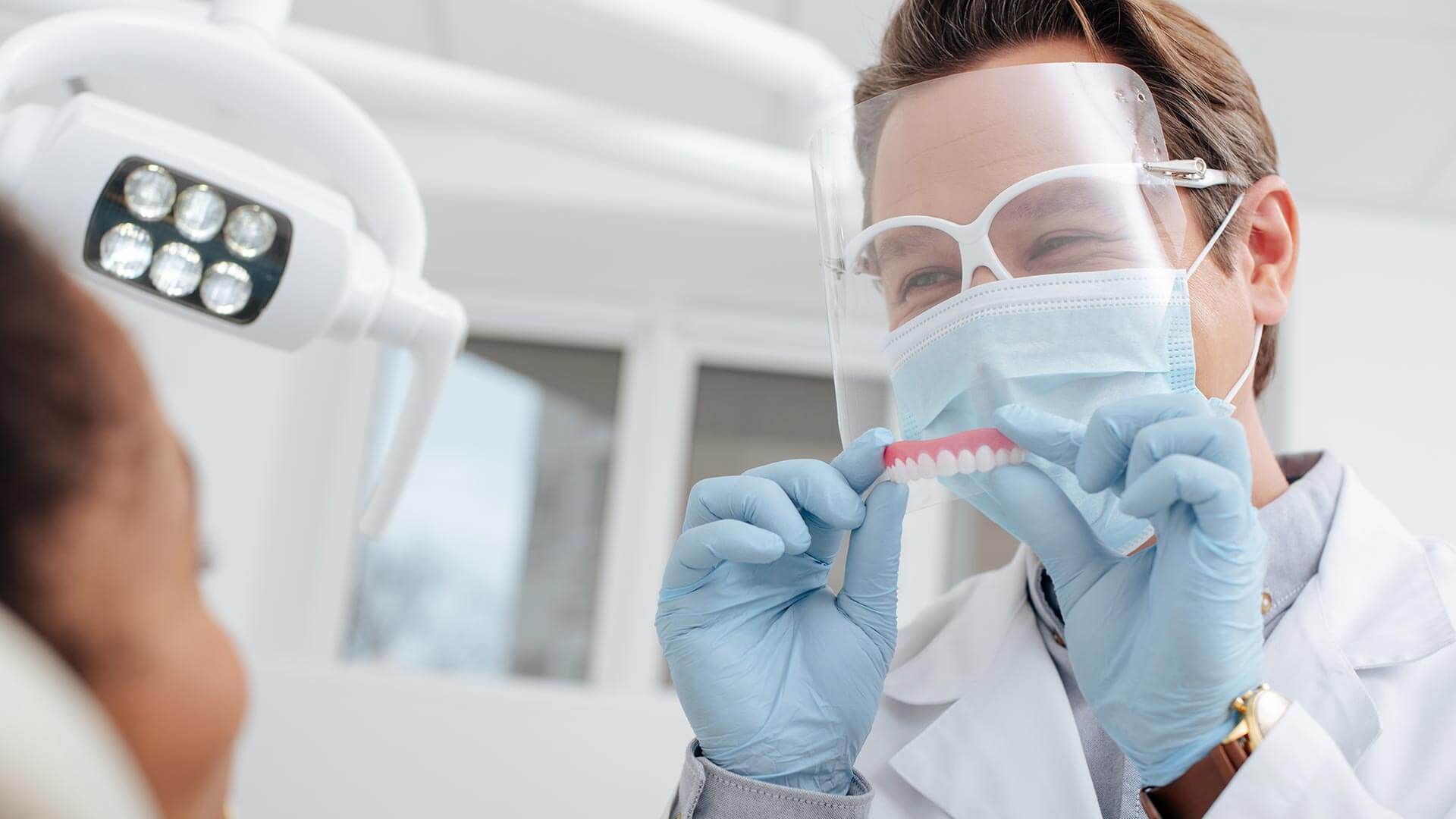 dentist wearing protective glasses and gloves while holding a toothbrush