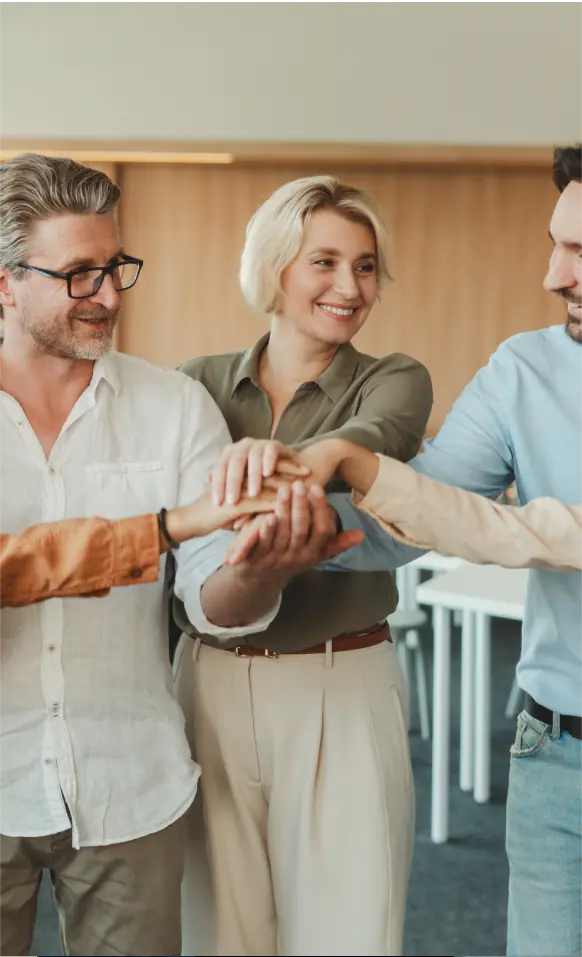 A group of people standing around each other holding hands.