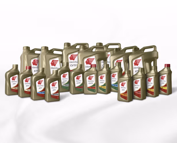 Collection of Idemitsu automatic transmission fluid containers in various sizes and types arranged on a white surface.