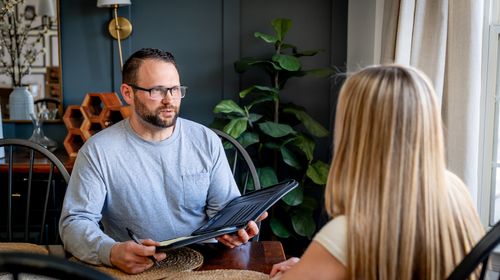 Picture of owner at the table with homeowner going over options