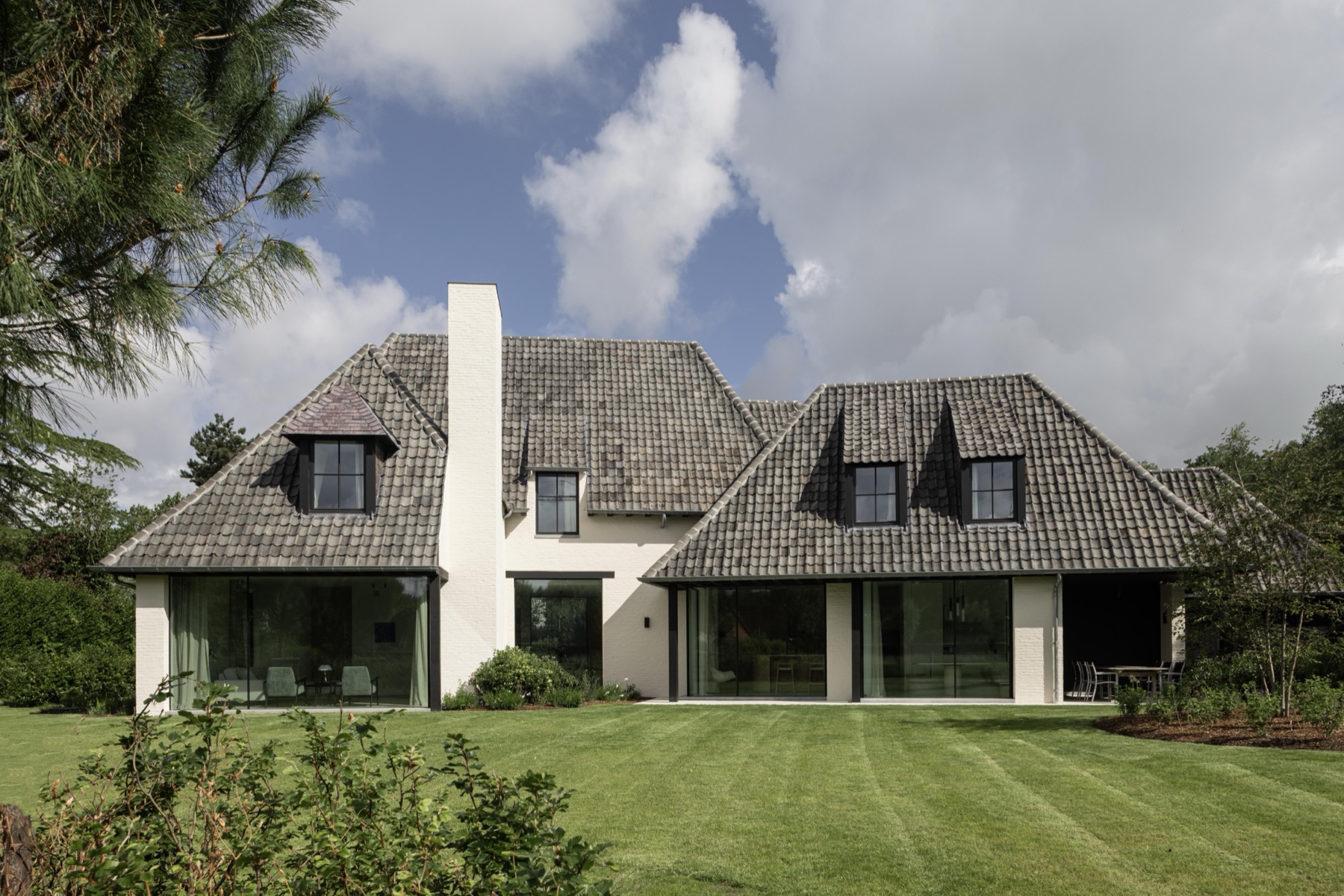 Landelijke nieuwbouwwoning met gekaleide gevel gezien vanuit de tuin